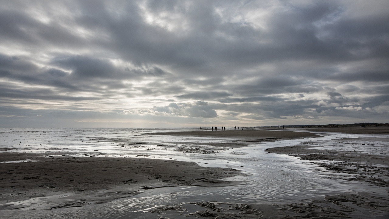 Wadlopen bij laagwater onder een dramatische hemel